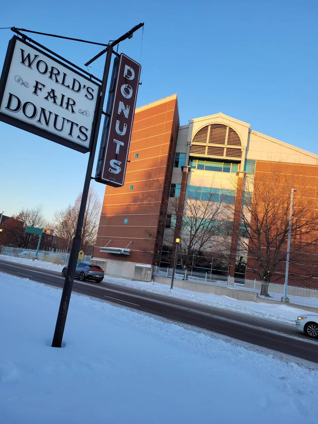 The World's Fair Donuts road sign and neon DONUTS blade above a snow-covered street in St. Louis